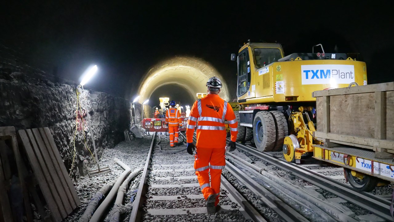 Network Rail engineer walking toward a tunnel towards work taking place at night time