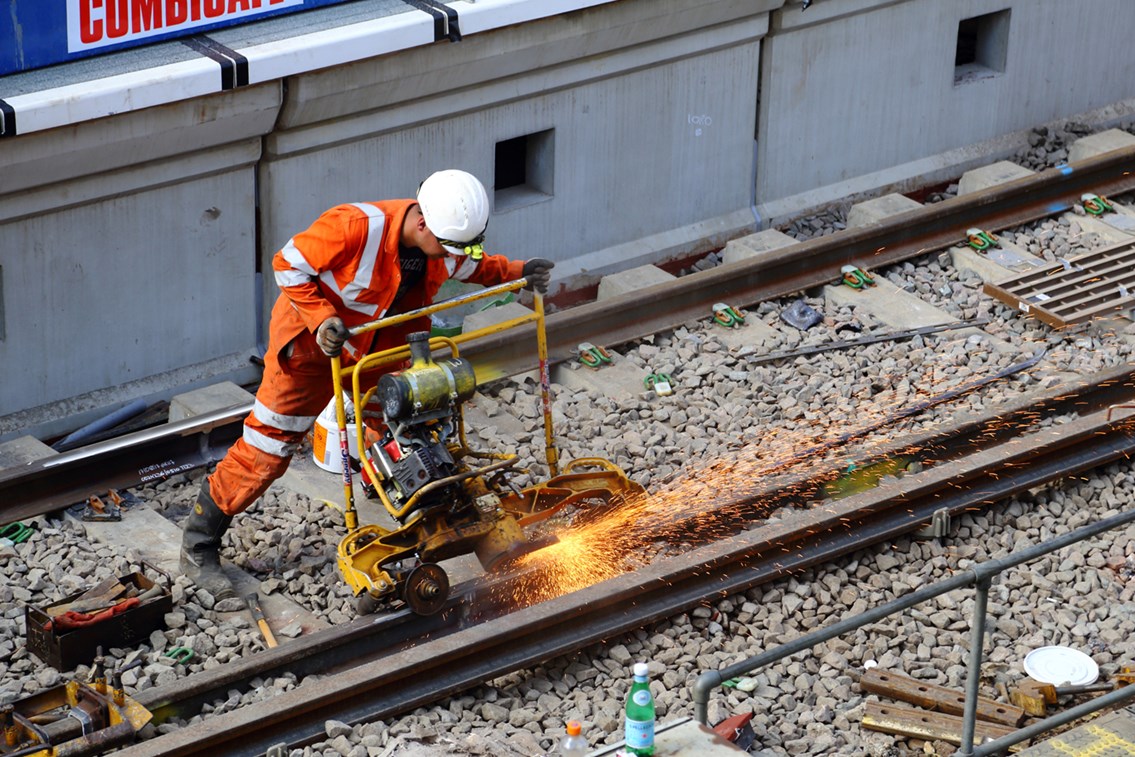 A rail worker in PPE working on track in South London.