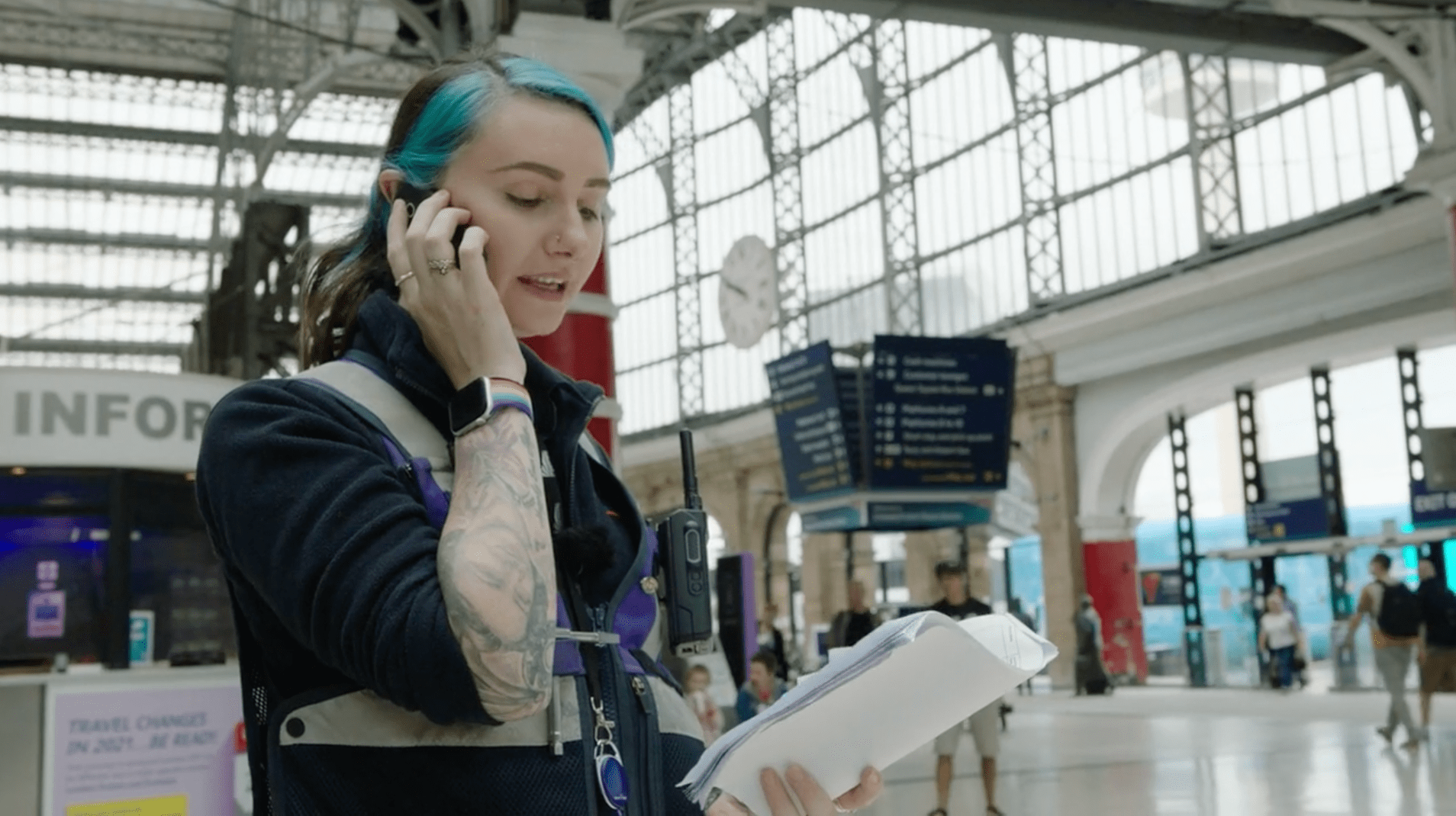 A customer services assistant on a phone call on the concourse at Liverpool Lime Street station, daytime