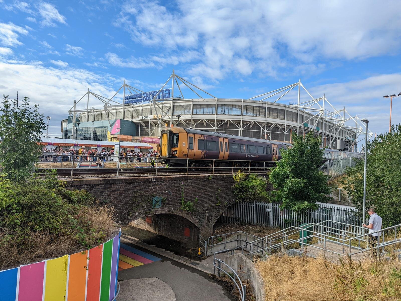 West Midlands trains on the railway outside of the Coventry Arena with Commonwealth Games 2022 branding.