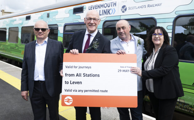 Politicians and Network Rail staff pose in front of a train with a giant mocked-up train ticket on the day of the official opening of the Levenmouth Rail Link.